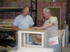 JPEG 86KB - Ed Kirkham and Eugene Estes put the back on a piece of office furniture.