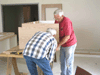 JPEG 67KB - Jack Tennison and Rick Sodergren are assembling a kitchen cabinet for the new convention Mission House.