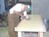 Rex Taylor fills a crack in a table top.