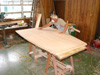 Jack Tennison is finish sanding one half of a conference table.