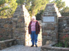 Freda Berry stands in the entrance gate to the original prayer garden on the hill overlooking the main camp.