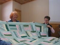 Rita Frantzen and Carolyn Adcock display the quilt Rita made.