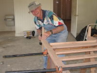 Charles Bingaman completes the assembly of a headboard by putting on its temporary feet.
