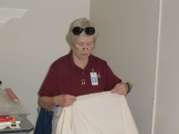 Sue Brewer works on a large table cloth for the conference room at Glorieta.