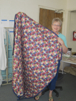 Patsy Nafe displays one of the quilts she made.